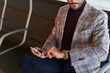 © Ivan Gener/Stocksy - Man with a phone checking the time in an airport lounge