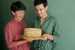 © Duet Postscriptum/Stocksy - Adult mother and adult daughter pose with homemade cake