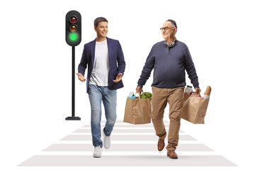 Wall Mural - Young man and mature man with grocery bags walking at a pedestrian crosswalk and talking