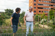 © Pedro Merino/Stocksy - Mature men working in a community urban garden.