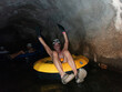 © Amy Covington/Stocksy - A man in an inner tube a river tunnel
