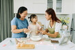 © Marc Tran/Stocksy - women family grandmother, mother and granddaughter cooking at home