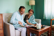 © Saptak Ganguly/Stocksy - Senior couple browsing through old photo album having morning tea