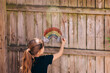 © Marisa Magnusen/Stocksy - Rainbow chalk drawing on fence