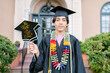 © ByLorena/Stocksy - Teen boy with banner on his graduation day