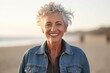 © Eber Braun - Portrait of happy senior woman smiling at camera on beach during sunset