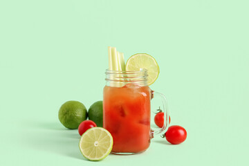 Fototapeta mason jar of bloody mary with celery and lime on green background