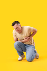 Poster - Young man having heart attack on yellow background