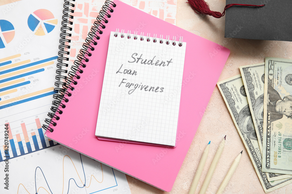 Notebook with text STUDENT LOAN FORGIVENESS, pencils, dollar banknotes and charts on beige table