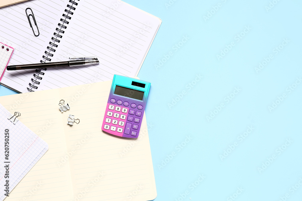Modern calculator with stationery on blue background