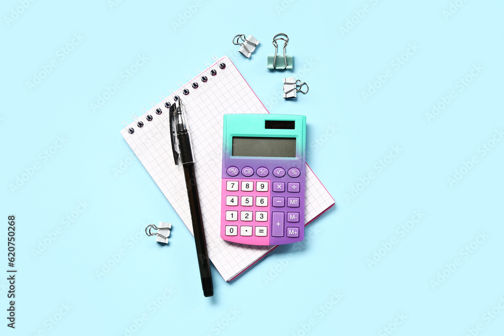 Modern calculator with stationery on blue background