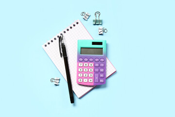 Wall Mural - Modern calculator with stationery on blue background