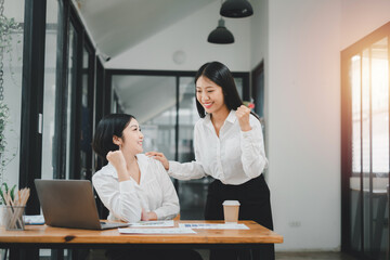 Beautiful two asian girl celebrate with laptop, success happy pose, E-commerce, university education, internet technology, or startup small business concept.