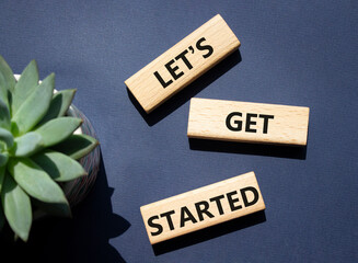 Wall Mural - lets get started symbol. concept words lets get started on wooden blocks. beautiful deep blue backgr