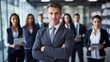 © Pro Hi-Res - Confident adult businessman looking successful with crossed arms. Blur smiling business team on background.