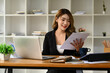 © Prathankarnpap - Charming asian woman entrepreneur using laptop, working on investment and marketing projects at modern office