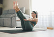 © ADDICTIVE STOCK - Focused sportswoman performing Navasana pose at home