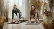 © ADDICTIVE STOCK - Couple doing runner Lunge yoga pose on mat in room