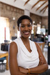 © Wavebreak Media - Portrait of happy african american casual businesswoman with arms crossed in creative office