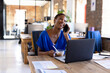 © Wavebreak Media - Happy african american casual businesswoman talking on smartphone and having lunch in office