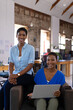 © Wavebreak Media - Portrait of happy african american colleagues using laptop in creative office