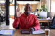 © Wavebreak Media - Portrait of happy african american casual businessman having video call and waving hand in office