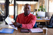 © Wavebreak Media - Portrait of african american casual businessman having video call holding document in office