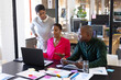 © Wavebreak Media - African american colleagues with documents and graphs on table using laptop in office