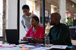 © Wavebreak Media - African american colleagues with documents and graphs on table using laptop in office