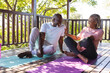© Wavebreak Media - Happy senior african american couple talking on mats on terrace