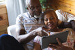 © Wavebreak Media - Senior african american couple lying on sofa and using tablet at home