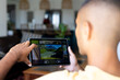 © Wavebreak Media - Biracial man sitting in living room using tablet with home security camera views on screen
