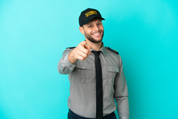 Wall Mural - Young security man isolated on blue background points finger at you with a confident expression