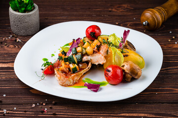 Wall Mural - Pork fillet with grilled vegetables champignons, zucchini, tomatoes, red pepper and spices in a plate.