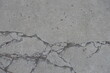 Worn dry light grey concrete slab with numerous cracks