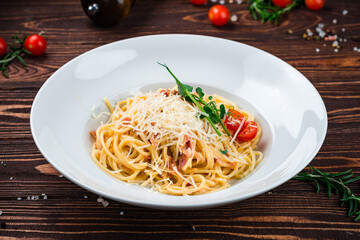 Poster - Spaghetti with bacon, cherry tomatoes, parmesan cheese and herbs in a plate.