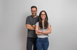 © Moon Safari - Portrait of smiling young couple wearing eyeglasses and casuals standing confidently against background. Joyful handsome man and beautiful woman posing with arms crossed