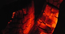 Extreme Close-up Of A Burning Hearth. Wooden Logs Smolder Brightly In The Fire. Beautiful Background With Copy Space. Bright Flames Of Fire Over Black Background, Slow Motion 50 Fps 4k