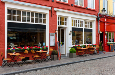 Wall Mural - Old cozy street with tables of restaurant in Bruges (Brugge), West Flanders province, Belgium. Cityscape of Bruges.