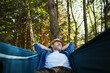 © baranq - Adult man chilling in hammock in a forst during summer vacation