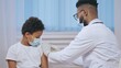 © Synthex - Doctor making vaccine injection to little boy in hospital, disease prevention