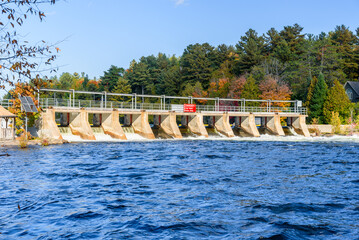 Wall Mural - Small dam for flood control on a river on a clear autumn day