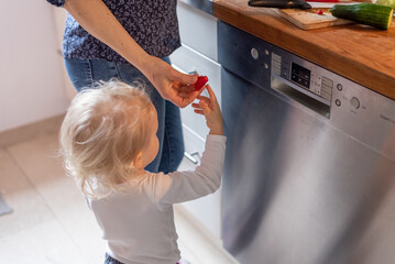  Woman giving tomato her little child, mother and son