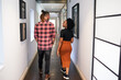 © Meeko Media - Two colleagues walking and talking in hallway, exiting the office building