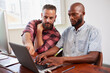 © Meeko Media - Two developers peer programming together in office, coding side by side