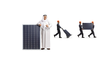 Wall Mural - Arab man pointing at a solar panel and workers carrying panels in the back