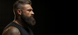 Brutal bearded man of strong physique on a black background.