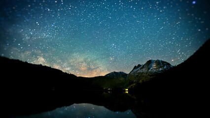 Wall Mural - amazing time-lapse of the night sky with the stars being reflected in a lake.