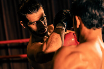 Asian and Caucasian Muay Thai boxer unleash elbow attack in fierce boxing match. Thai boxer with strong muscular body exchanging punch and elbow strike with relentless combat prowess. Impetus