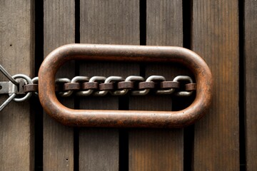 A rusted chain hanging from an old wooden dock